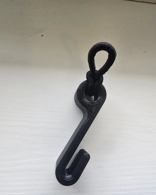 Sort 3D-printet krok med hårstrikk gjennom øyet