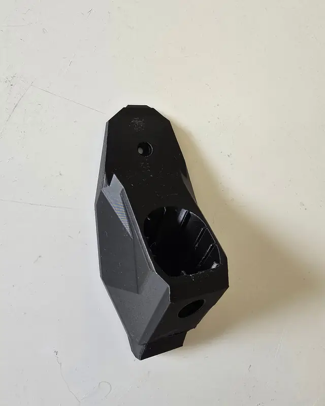 Sort veggmontert holder til Ryobi One Plus-batteri